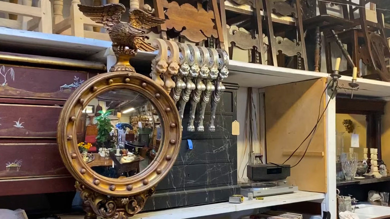 A round mirror with an eagle on top of it.