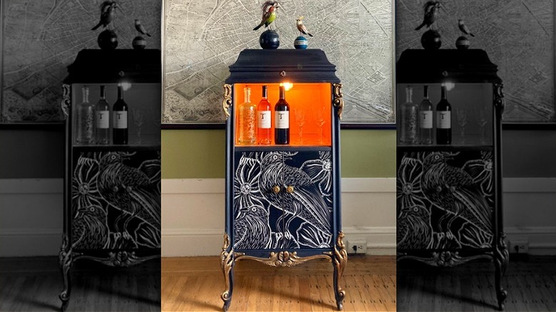 Victrola record player turned into a bar cabinet with wine bottles and bird motifs