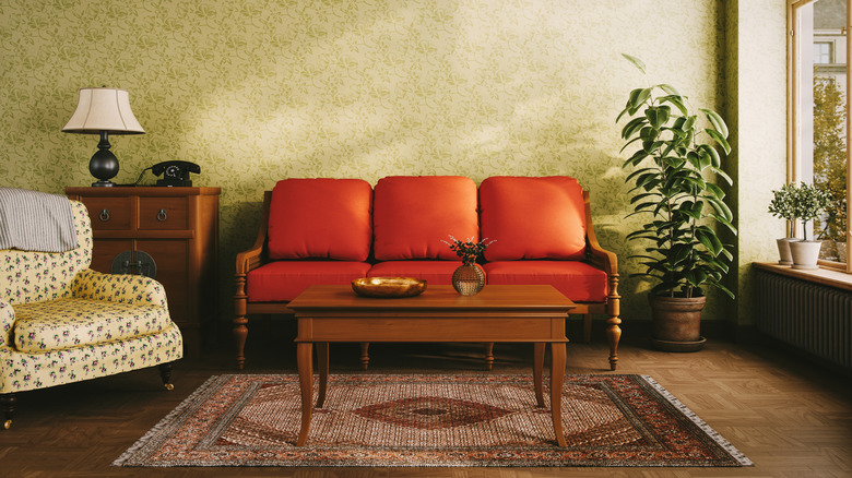 A retro-style living room with an orange sofa and a rotary phone