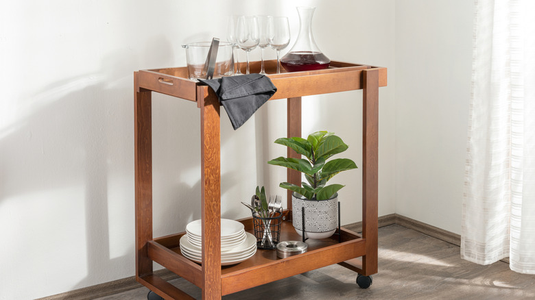 a wooden vintage hostess trolley with dishware on it