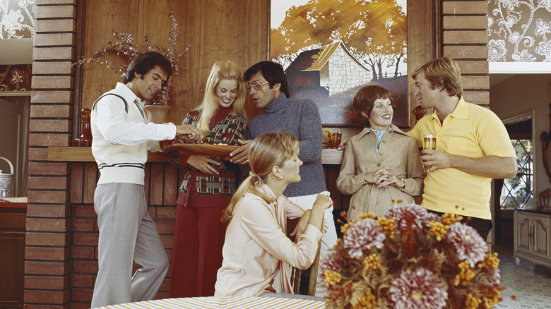A social gathering in the 1970s at someone's period-decorated home