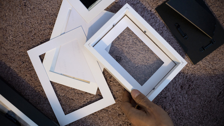 Person holding small open photo frame.