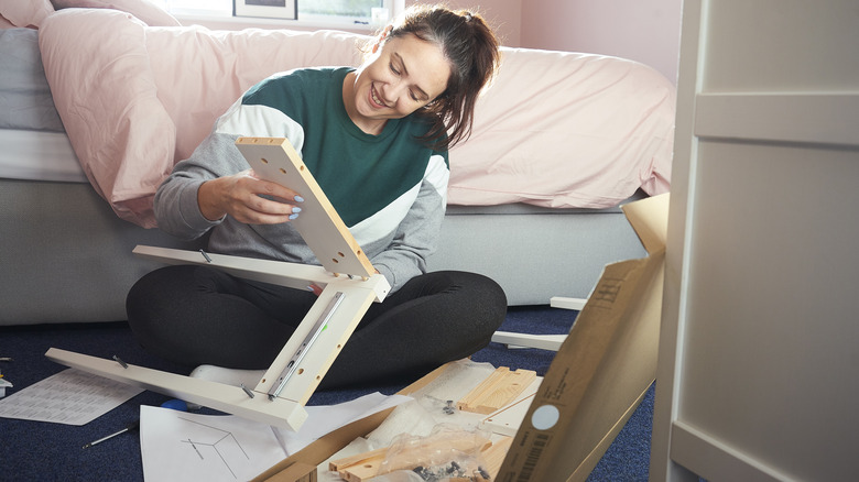 woman building ikea nightstand