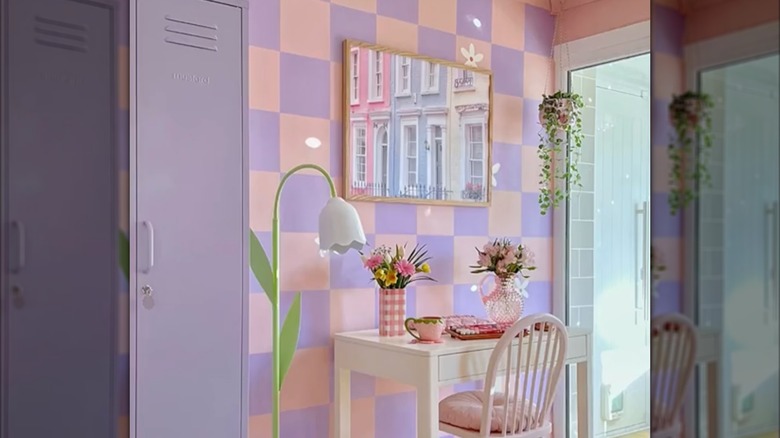 Modern pink and purple checkerboard wall behind a white desk and flowers