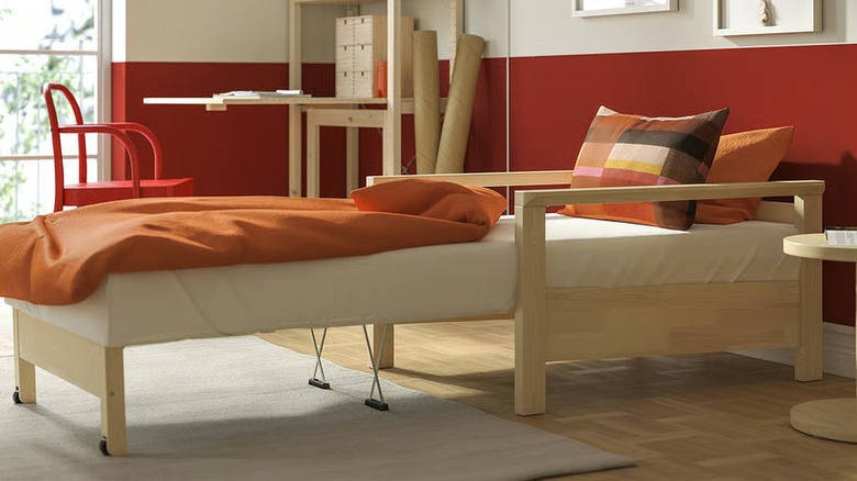 IKEA TORNSBORG chair-bed extended into bed with orange bedding