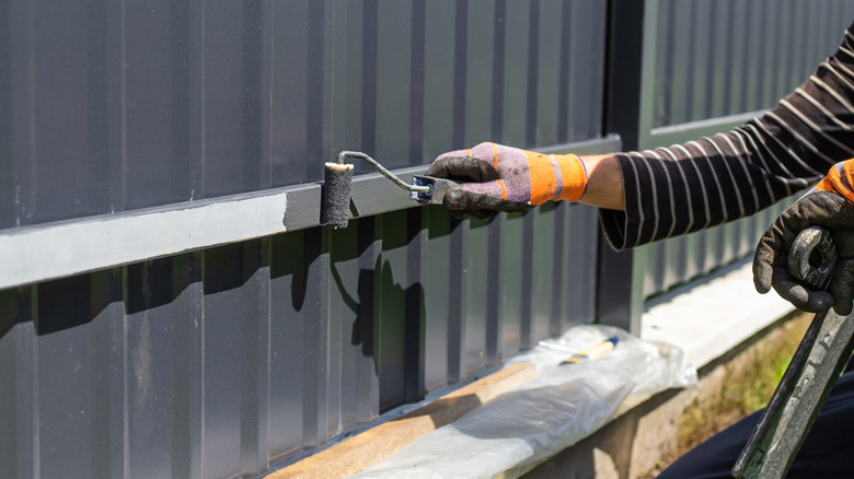 Painting a fence gray with a brush
