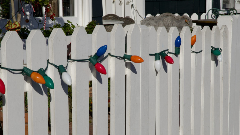 White picket fence with holiday string lights