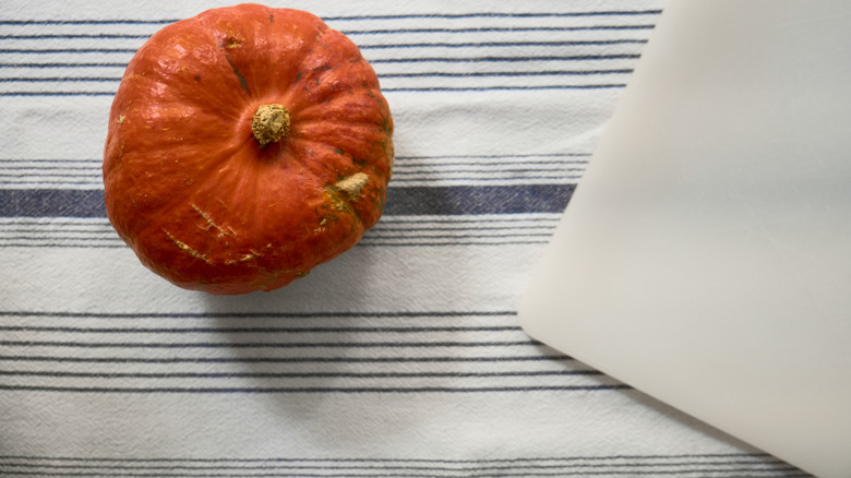 pumpkin on top of striped table cloth