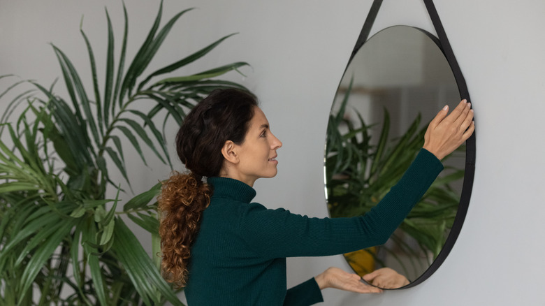 Woman hanging a mirror