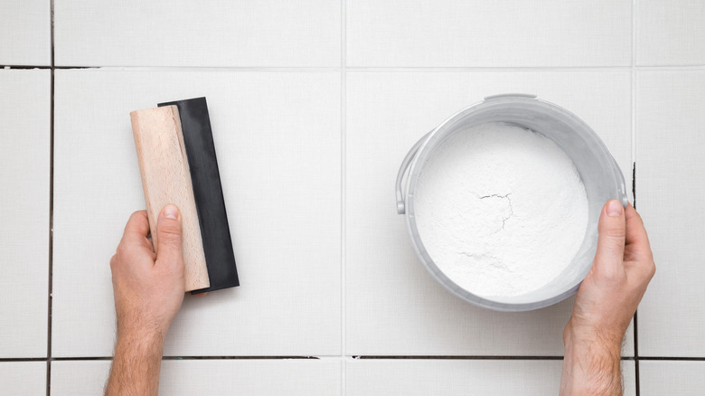 Hands grouting tiles