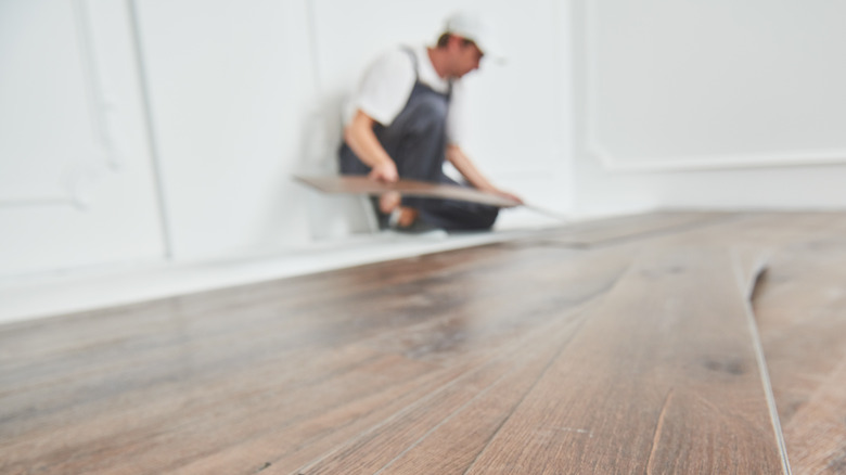 worker preparing laminate flooring