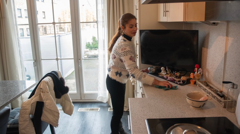 woman wiping countertop with a cloth
