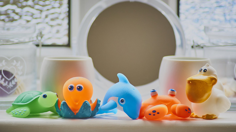 Colorful plastic bath toys shaped like sea animals on a ledge in the bathroom