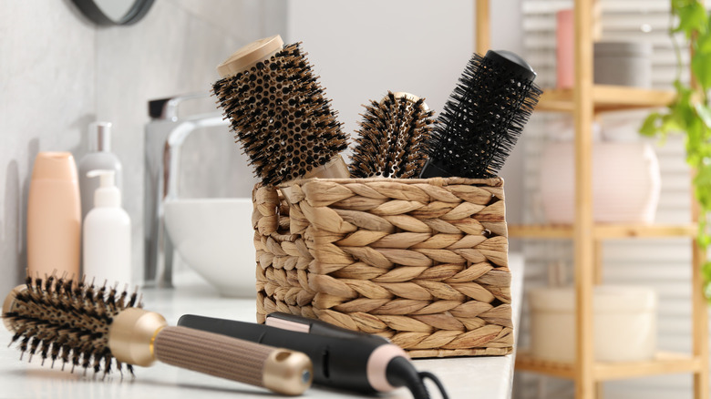 Brushes and hair styling tools on a bathroom countertop