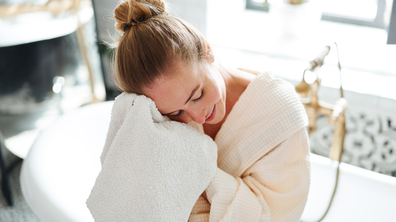 Woman drying face with bath towel