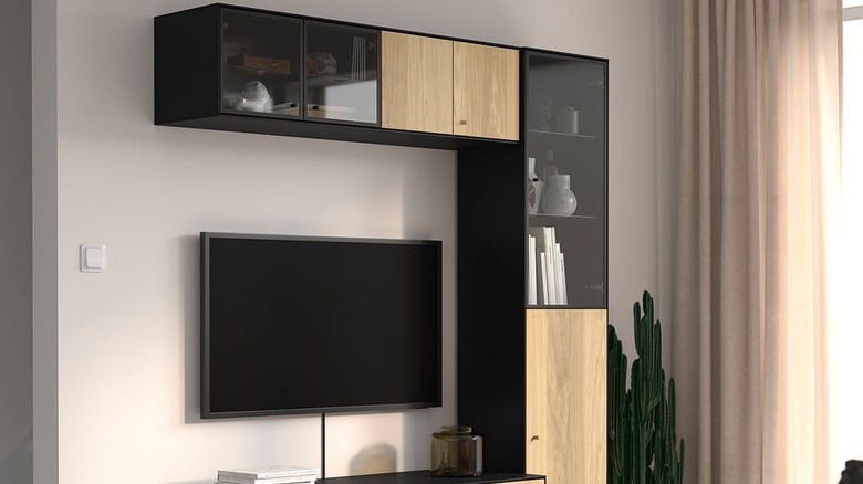 The BOASTAD TV storage combination with a TV in the center and decorations in the glass compartments