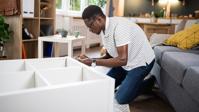 man building an IKEA storage unit