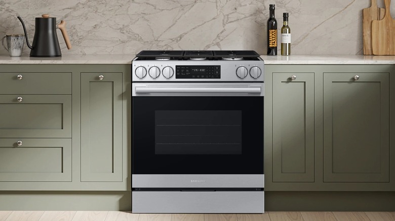 The Samsung Bespoke Smart Slide-in Gas Range in a kitchen with sage green cabinets