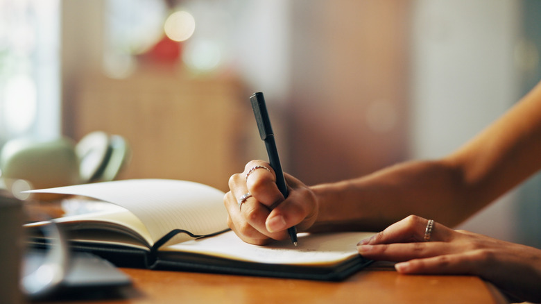 Woman jotting down her goals in a notebook