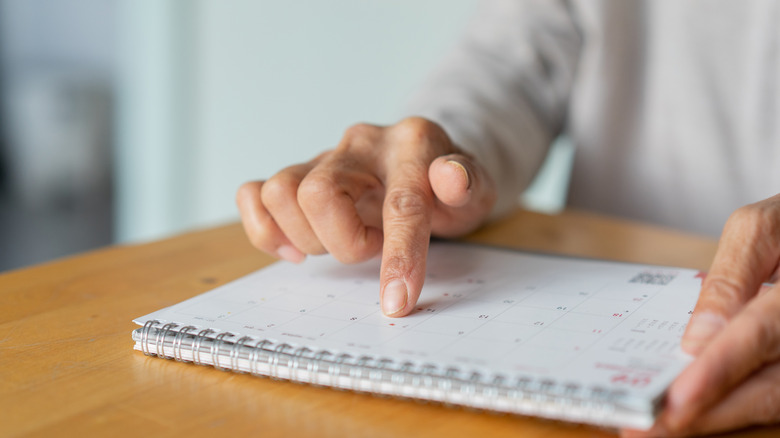 Hand picking date from a desk calendar