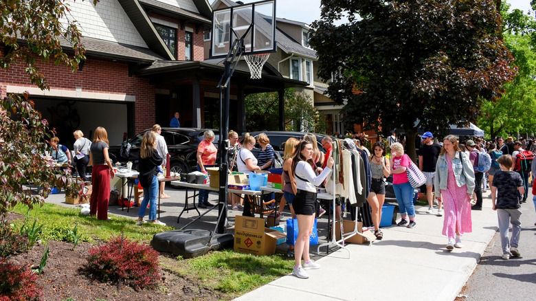 People milling about a garage sale in a driveway