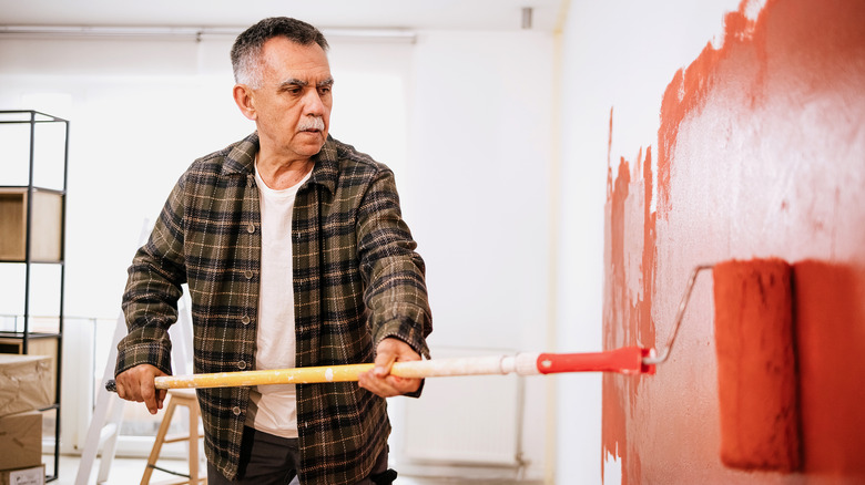 man painting wall red