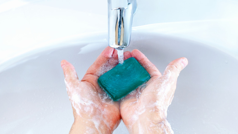 Washing hands with bar of soap 