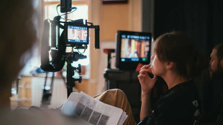 director by camera filming scene