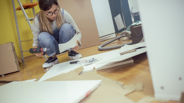 woman putting together IKEA cabinets