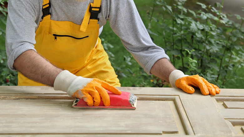 Person sanding a wood door