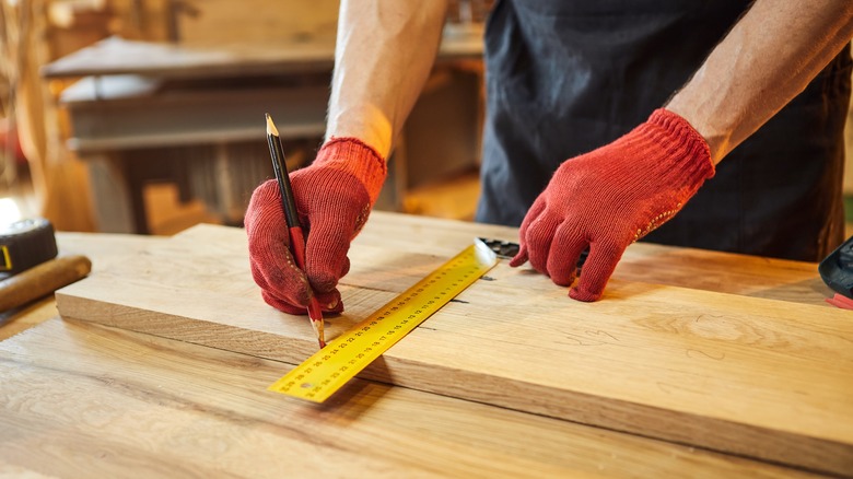person measuring wood