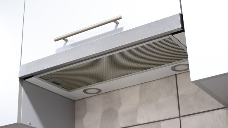 An extractor hood concealed in the bottom of a cabinet