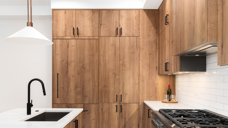 A kitchen with wooden floor-to-ceiling cabinets