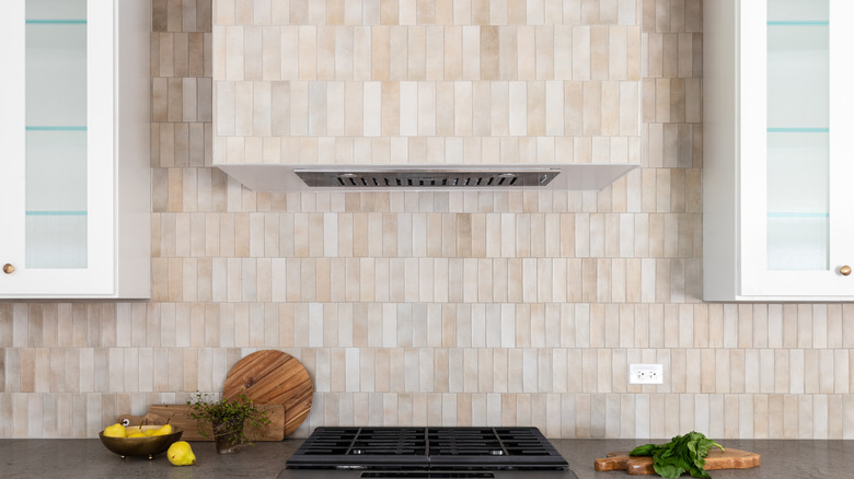 A full-height backsplash that extends from the counter, all the way up the wall, and around the extractor hood