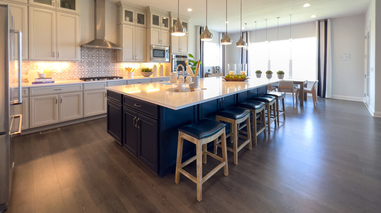 A contemporary kitchen showing an island finished in contrasting colors to the rest of the kitchen's cabinets