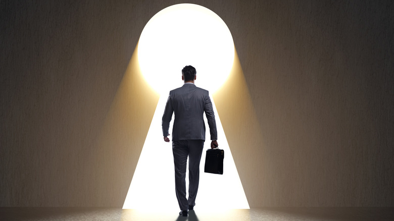 Man walking into a key hole.
