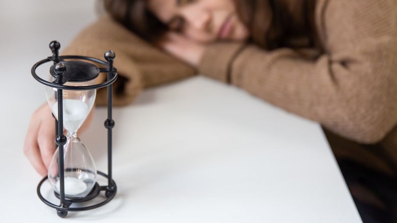 Hourglass and tired woman