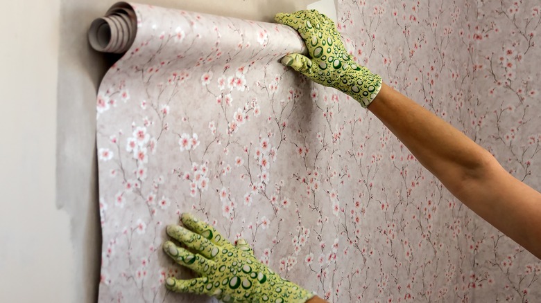 person installing wallpaper
