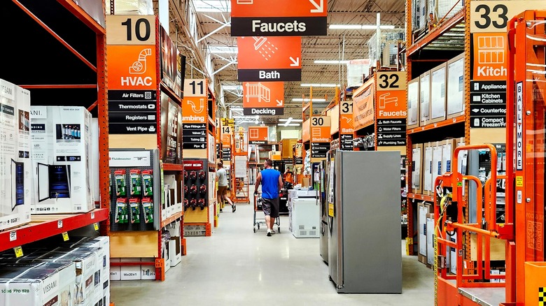 Two shoppers walk down the aisles at Home Depot.