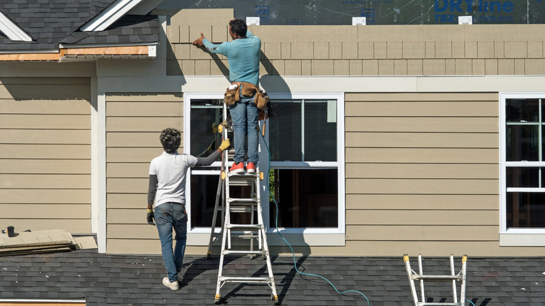 Two men installing fiber cement siding