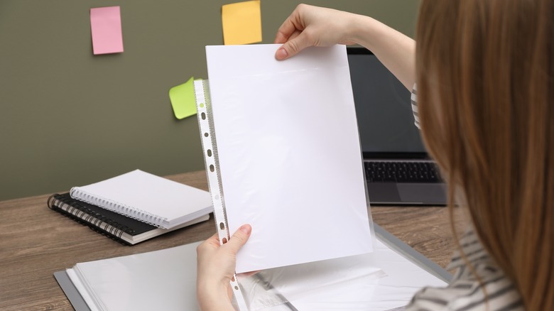 woman using sheet protector for paper