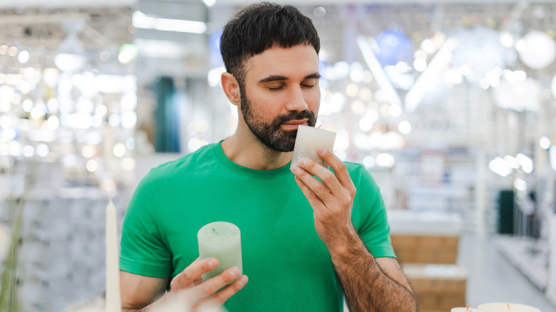 a man holds small candles in a store