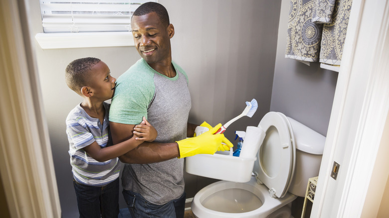 Father and son cleaning toilet
