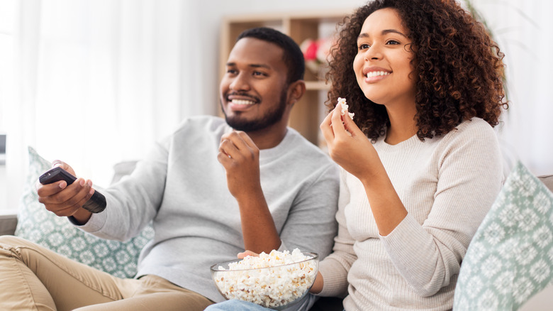 couple eating popcorn watching TV