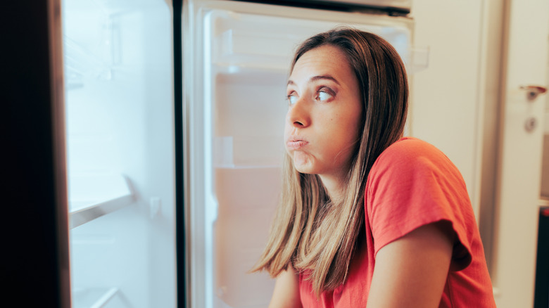Women looking frustrated after opening her refrigerator