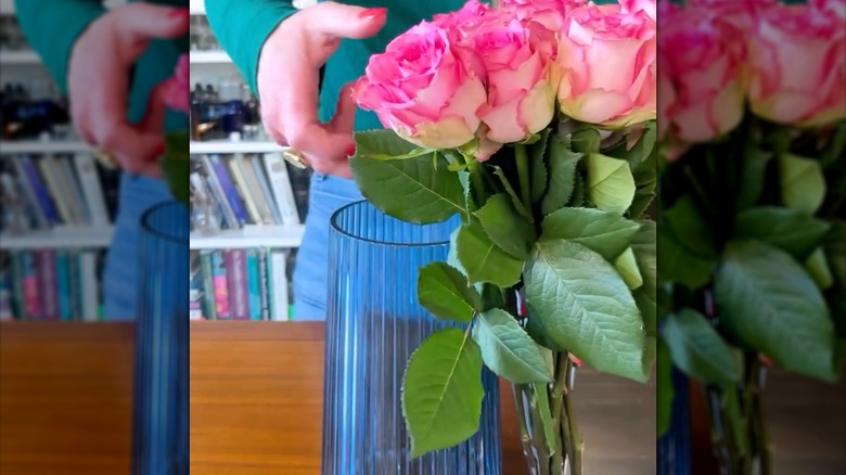 Picture of woman measuring with fingers to determine where to cut rose stems