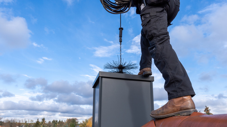 Chimney sweep cleaning a chimney