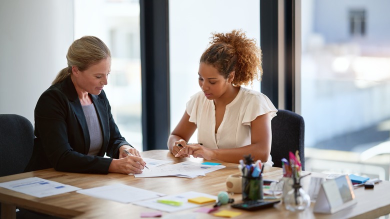A woman speaking with a lawyer in an office.