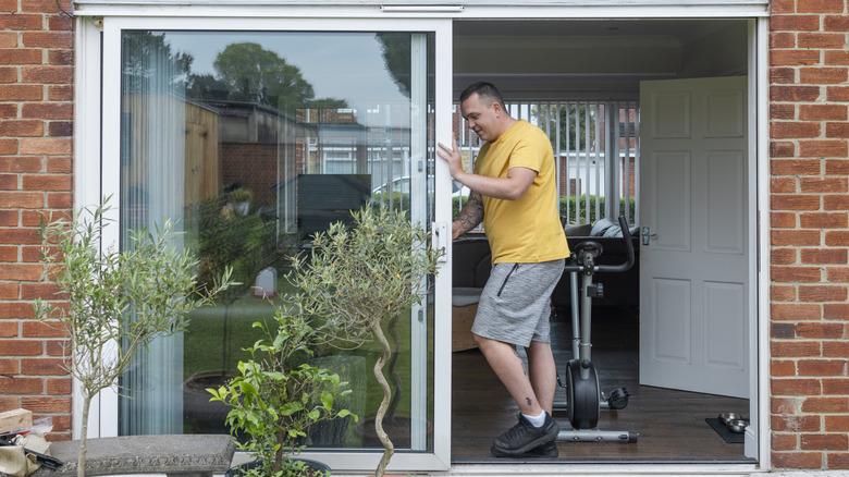 man opening sliding glass door
