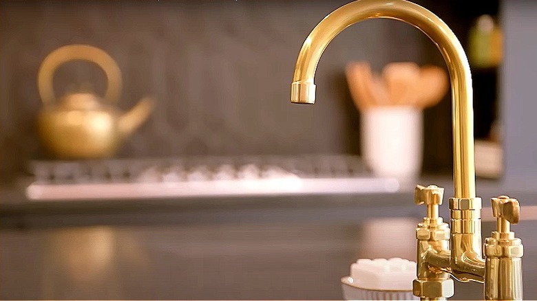 Brass faucet in black kitchen